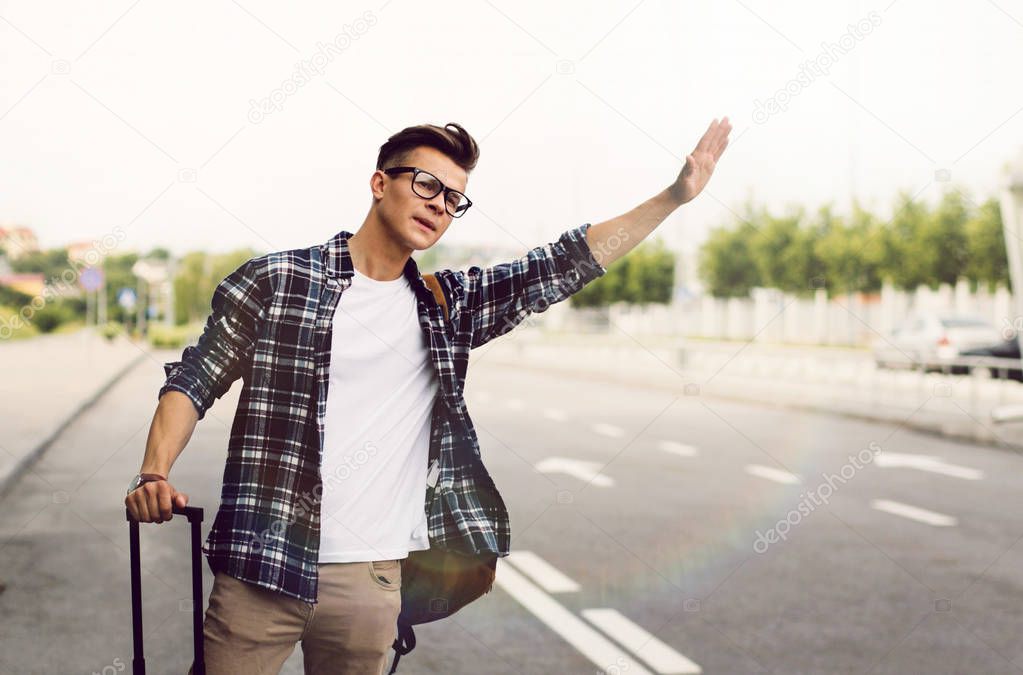 Man catching taxi. Young man traveler catching taxi at the airport.