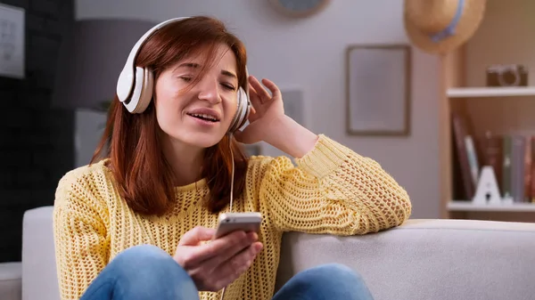 Retrato de mulher feliz em casa é escuta música em fone de ouvido — Fotografia de Stock