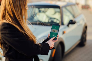 Car yakınındaki bir iş kadını. Arabanın yakınında Smartphone kullanan kadın. Telefon denetiminde araba.