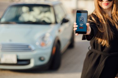 Car yakınındaki bir iş kadını. Arabanın yakınında Smartphone kullanan kadın.