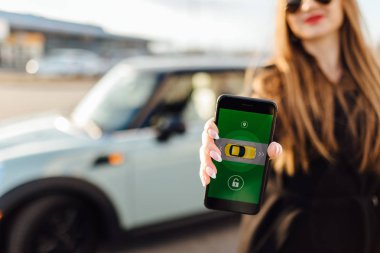 Car yakınındaki bir iş kadını. Arabanın yakınında Smartphone kullanan kadın. Telefon denetiminde araba.