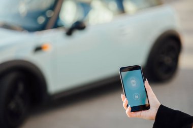 Car yakınındaki bir iş kadını. Arabanın yakınında Smartphone kullanan kadın. Telefon denetiminde araba.