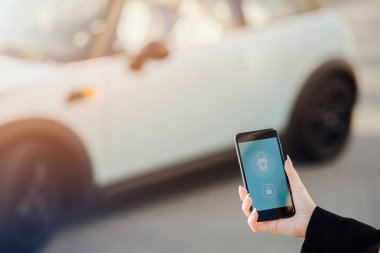 Car yakınındaki bir iş kadını. Arabanın yakınında Smartphone kullanan kadın. Telefon denetiminde araba.
