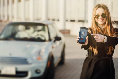 Car yakınındaki bir iş kadını. Arabanın yakınında Smartphone kullanan kadın.