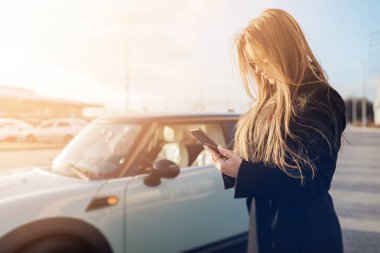Car yakınındaki Smartphone kullanan kız.