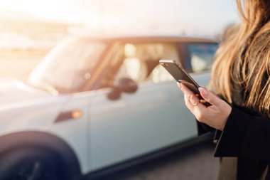 Car yakınındaki Smartphone kullanan kız.