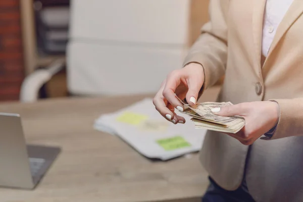 Businesswoman with cash. Hand holding dollar money.