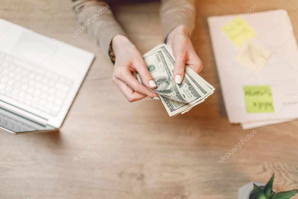 Businesswoman with cash. Hand holding dollar money.