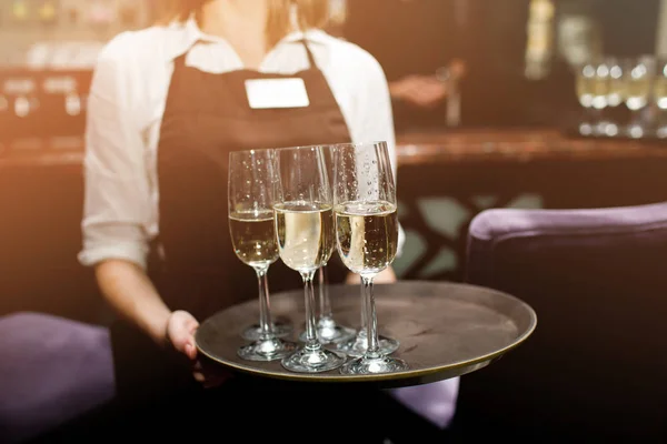 Waiter with champagne on a tray. Full glasses of champagne on tray