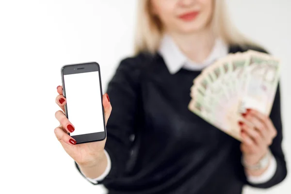 Nő tartja a pénzt, és használ smartphone. — Stock Fotó