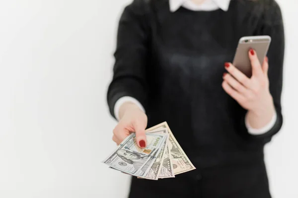 Donna in possesso di denaro e utilizzando smartphone . — Foto Stock