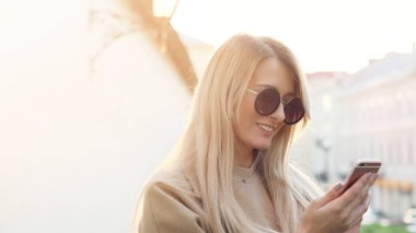 cep telefonu açık havada şehirde kullanan kadın.