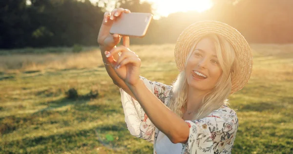 Jovencita alegre en sombrero tomando selfie con teléfono móvil . —  Fotos de Stock