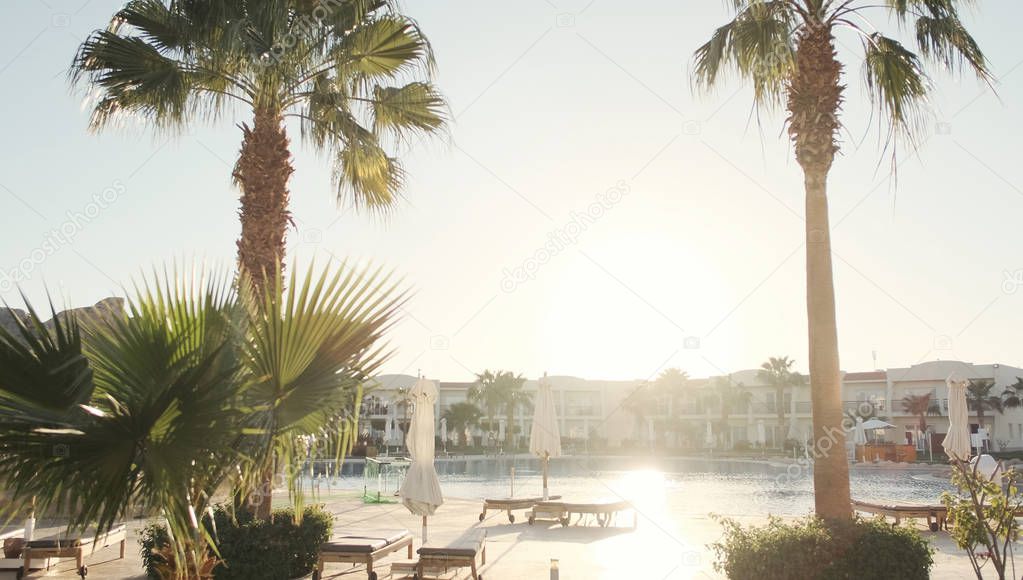 Summer vacation.Outdoor luxury swimming pool.  luxurious beachfront hotel resort at sunset.