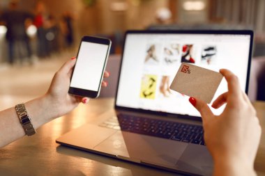 Online Alışveriş Konsepti. Online ödeme. Online alışveriş için akıllı telefon ve dizüstü bilgisayar kullanarak kadın eller. Ödeme Detayı sayfası ekranı.