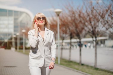 Akıllı telefonlar kullanarak ofis giysileri içinde Güzel Kadın Portresi. Ofise yakın telefonu olan İş Kadını. Telefon İletişimi.