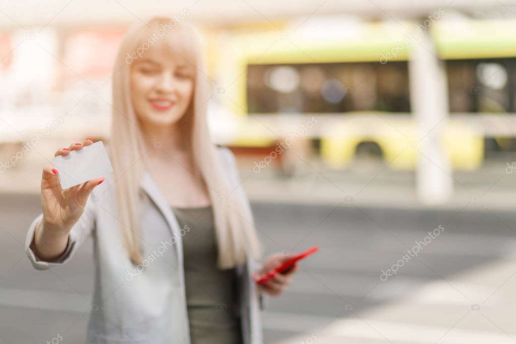 Portrait of  young woman stands on the bus stop. Girl waiting transport. Public transport.