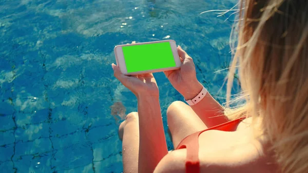 美丽的金发女孩与电话在游泳池 自由概念 — 图库照片