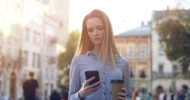 Şehirde yürüyen genç Avrupalı kadının portresi.