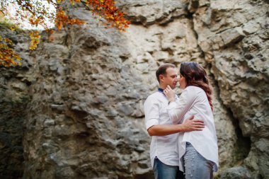 Romantik genç çift sonbahar parkında yürüyor. Parkta birlikte bir aile. Hamile çift.