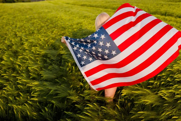 アメリカ国旗で7月4日を祝う若い女の子の背中 アメリカ国旗を掲げている女性 — ストック写真