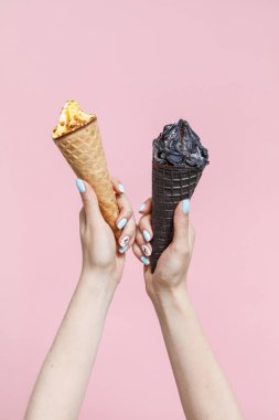 Renk arka planda bir waffle konileri içinde dondurma tutan kadın.