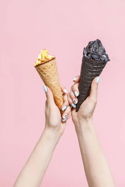 Woman holding Ice Cream in a waffles cones on color background.