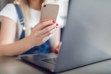 Kafede kahve içen ve cep telefonu kullanan genç kız. Online alışveriş