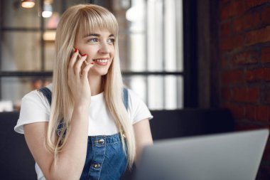 Kafede kahve içen ve cep telefonu kullanan genç kız. Online alışveriş