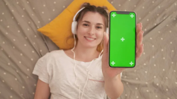 Szczęśliwa kobieta lub nastoletnie dziewczyny w słuchawkach słuchanie muzyki ze smartfona — Zdjęcie stockowe