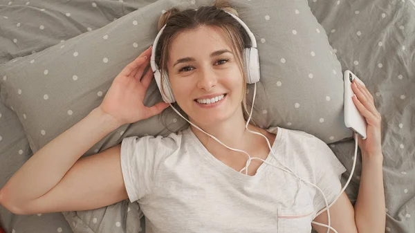 Glückliche Frau oder Teenager mit Kopfhörern, die Musik vom Smartphone hören — Stockfoto