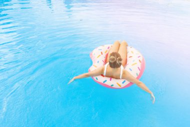 Havuzda şişme çörek rahatlatıcı beyaz bikini genç güzel kız havadan görünümü. Yaz Tatili