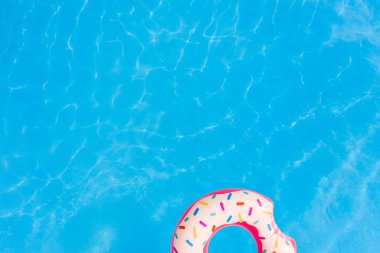 Yaz tatili. Yüzme havuzunda büyük pembe donut havadan görünümü.