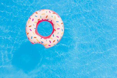 Yaz tatili. Yüzme havuzunda büyük pembe donut havadan görünümü.