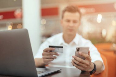 Akıllı telefon ve dizüstü bilgisayar kullanan bir adam. Kredi kartı Çevrimiçi Alışveriş Konsepti