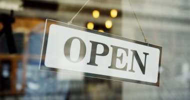 Close up of male baker hands turning a signboard on the glass door of the shop from OPEN to CLOSED. Bakehouse clipart