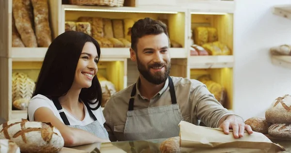 Encantadora Vendedora Panadería Vendiendo Baguettes Mientras Compañero Trabajo Ayuda —  Fotos de Stock