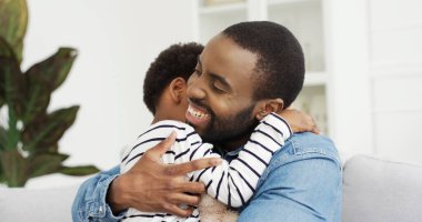 Afrika kökenli Amerikalı bir babanın şirin küçük kızına sarıldığının portresi. Babalar Günün kutlu olsun..