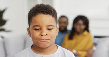 Portrait of african american little boy looking at camera on background of her parents. clipart