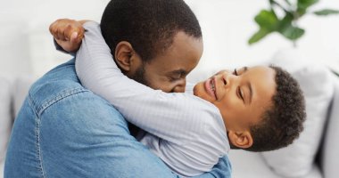 Küçük oğlunu kucaklayan Afrikalı Amerikalı babanın portresi. Babalar Günün kutlu olsun..