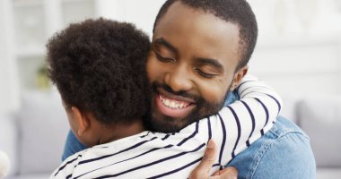 Küçük oğlunu kucaklayan Afrikalı Amerikalı babanın portresi. Babalar Günün kutlu olsun..