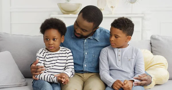 Portrét afrického amerického otce baví hrát si s dětmi sedícími na pohovce. — Stock fotografie