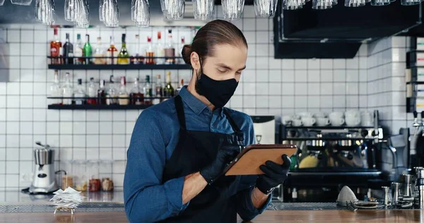 Maskeli Eldivenli Önlüklü Beyaz Bir Erkek Mutfaktaki Kafede Tablet Kullanıyor — Stok fotoğraf