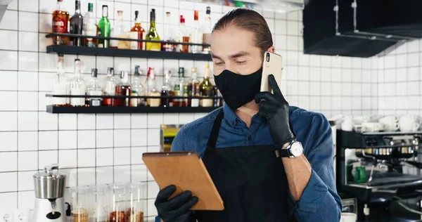 Yakışıklı Beyaz Bir Barmen Cep Telefonuyla Konuşuyor Barda Tablet Cihazını — Stok fotoğraf