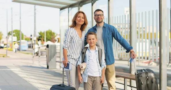 Otobüs durağında ya da tren istasyonunda duran bavulları olan beyaz mutlu bir ailenin portresi. Ailesi ve oğlu yazın seyahat ediyor. Anne ve babasıyla tatile çıkan çocuk tatilleri.