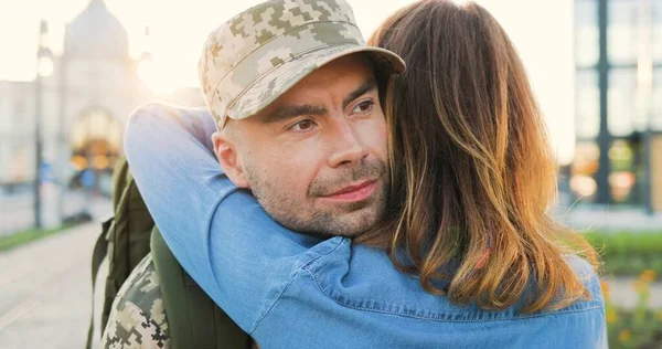 Genç, mutlu, beyaz bir çiftin buluşması ve sokakta kucaklaşması. Yakışıklı asker geri geliyor ve kız arkadaşını kucaklıyor. Ordudan kıza dönen bir asker. Arka..