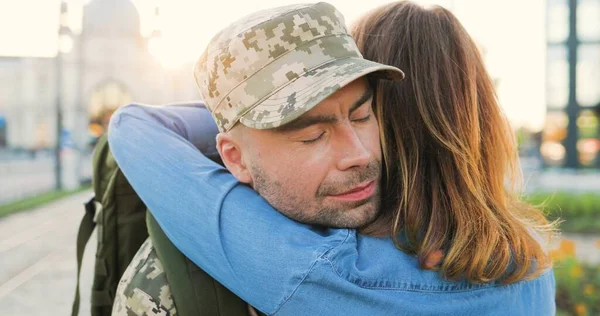Genç, mutlu, beyaz bir çiftin buluşması ve sokakta kucaklaşması. Yakışıklı asker geri geliyor ve kız arkadaşını kucaklıyor. Ordudan kıza dönen bir asker. Arka..