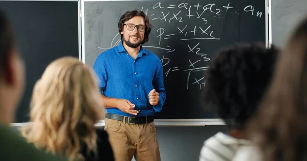 Vit man lärare i glasögon i skolan på svarta tavlan prata med elever eller studenter. Matte klass koncept. Man föreläsare förklara matematik lagar på lection. Utbildningsidé. — Stockfoto
