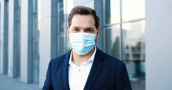 카프카스 출신잘생긴 남성이 의료용 마스크를 카메라를 매력적 스타일의 사업가가 거리에서 — 스톡 사진