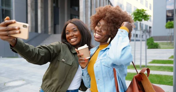 아프리카계 미국인젊고 여성들이 웃으며 카메라 앞에서 웃으며 거리에서 핸드폰 카메라로 — 스톡 사진